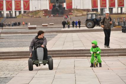 Москва. Корреспондент `Комсомольской правды ` Павел Клоков тестирует веломобиль на дорожках парка Победы.