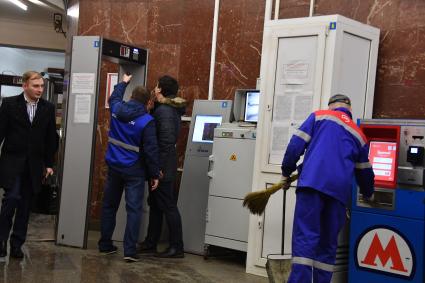 Москва. Усиление мер безопасности в московском метрополитене после взрыва в вагоне метро в Санкт-Петербурге. Сотрудник службы безопасности объясняет корреспонденту `Комсомольской правды` Павла Клокова принцип работы рамки металлоискателя на станции.