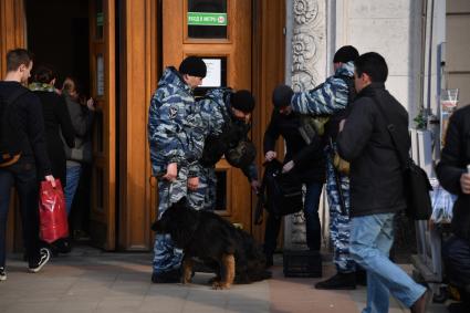 Москва. Усиление мер безопасности в московском метрополитене после взрыва в вагоне метро в Санкт-Петербурге. Сотрудники полиции с собакой во время досмотра вещей при входе в метро.