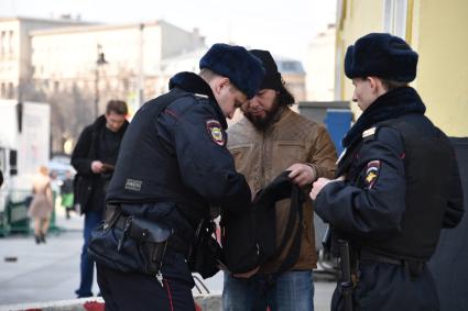 Москва. Усиление мер безопасности в московском метрополитене после взрыва в вагоне метро в Санкт-Петербурге. Сотрудники полиции во время досмотра вещей при входе в метро.