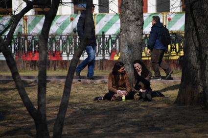 Москва. Девушки сидят на газоне.