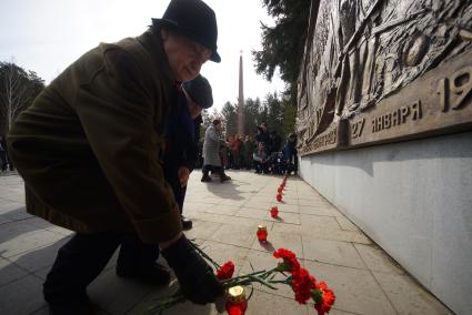 Екатеринбург. Широкореченский военный мемориал. Люди возлагают цветы к барельефу \'Блокада Ленинграда\' во время траурного митинга в память о жертвах терракта в метро в Санкт-Петербурге