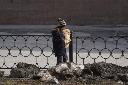 Екатеринбург. Мальчик переносит на руках маленькую собачку через грязь