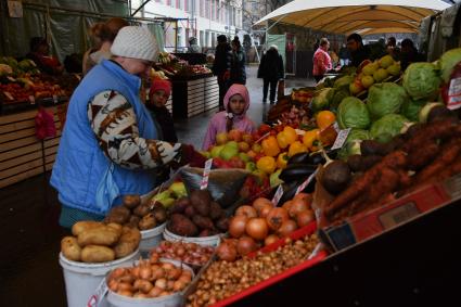 Москва. Покупатели  и продавцы на ярмарке выходного дня.