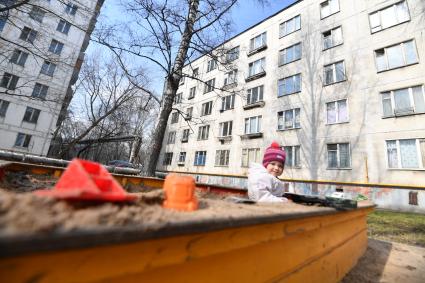 Москва. Ребенок играет в песочнице пятиэтажного дома на Полярной улице.