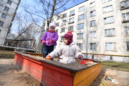 Москва. Дети играют  в песочнице пятиэтажного дома на Полярной улице.