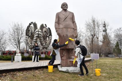 Москва. Молодые люди на общегородском субботнике `За чистоту икусства` в парке  `Музеон` моют памятник  Владимиру Ленину.