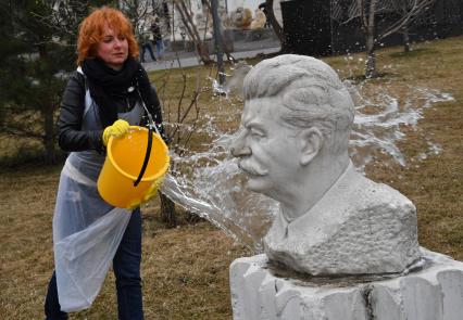 Москва. Участница общегородского субботника `За чистоту икусства` в парке  `Музеон` моет памятник Иосифа Сталина.