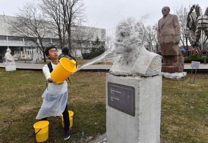 Москва. Молодой человек во время  общегородского субботника `За чистоту икусства` в парке  `Музеон` моет памятник Владимиру Ленину.