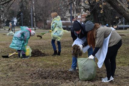 Москва. Участники общегородского субботника`За чистоту икусства` в парке `Музеон` убирают сухие листья с газона.