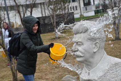 Москва. Участница общегородского субботника `За чистоту икусства` в парке  `Музеон` моет памятник Иосифу Сталину.