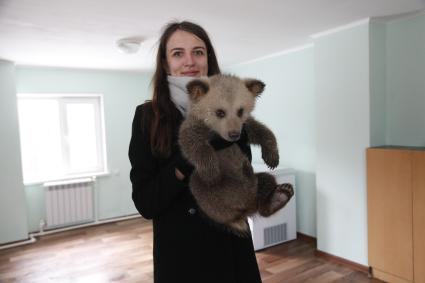 Уфа. Девушка держит на руках бурого медвежонка, родившегося в вольере в парке Лесоводов.