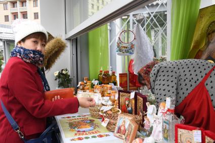 Москва.  Китайские туристы покупают сувениры в палатке на одной из площадок фестиваля  `Пасхальный дар`.