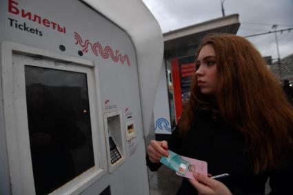 Москва. Девушка с социальной картой москвича у платежного терминала Мосгортранса.