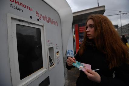 Москва. Девушка с социальной картой москвича у платежного терминала Мосгортранса.