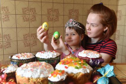 Москва.  Мама  с девочкой  рассматривают пасхальные  яйца.