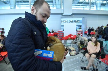 Москва. Корреспондент `Комсомольской правды` Евгений Беляков   держит на руках щенка  на выставке-продаже  щенков и котят  разных пород `БЭСТики ШОУ`в  Крокус Экспо.