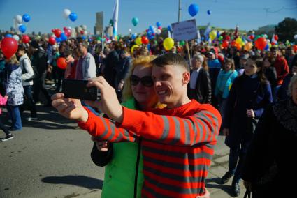 Екатеринбург. Участники первомайской демонстрации фотографируются на фоне шествия колонны профсоюзов в день весны и труда.