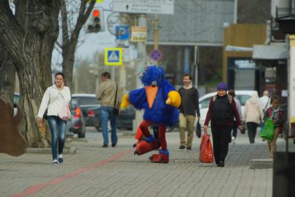 Екатеринбург.Человек в костюме птицы идет крошить хлеб у стен музея истории Екатеринбурга, проверяя работу \'человека-антиголубя\'