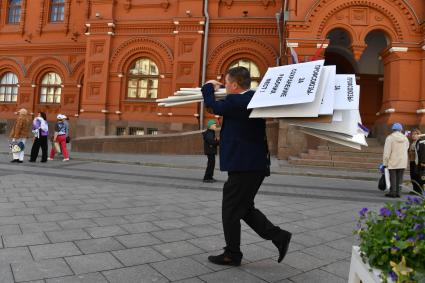 Москва. Мужчина несет плакаты после певомайской демонстрации.