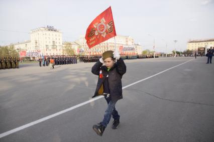 Барнаул. Репетиция Парада Победы. Мальчик с красным флагом идет мимо парадных расчетов.