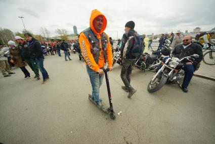 Екатеринбург.Байкер на самокате едет ммимо мотоциклов, во время открытия мотосезона