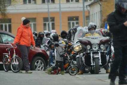 Екатеринбург. Женщина с ребенком на велосипедами проходям мимо колонны мотоциклистов во время открытия мотосезона