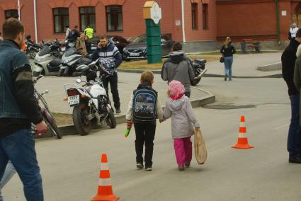 Екатеринбург. Мальчик с девочкой идут мимо мотоциклов во время открытия мотосезона