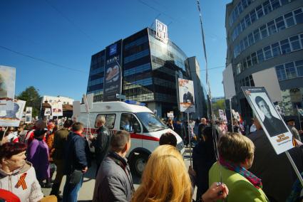 Екатеринбург. Машина скорой помощи проезжает через толпу участников шествия \'Бессмертный полк\'