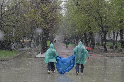 Москва.  Мужчины в плащах идут по Тверскому бульвару.