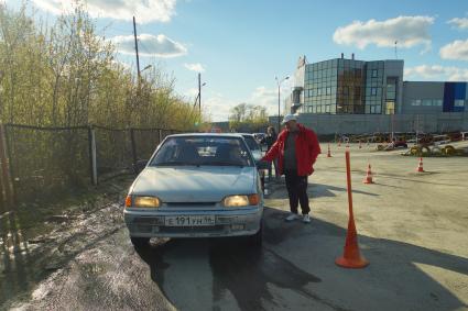 Ектеринбург. Автодром ДОСААФ. Курсанты перед началом выполнения упражнения на учебном автомобиле, на площадке по подготовке водителей категории \'Б\'