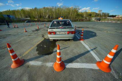 Ектеринбург. Автодром ДОСААФ. Курсант выполняет упражнение \'параллельная парковка\' на учебном автомобиле на площадке по подготовки водителей категории \'Б\'