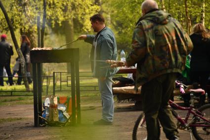 Москва. Отдыхающие во время приготовления шашлыка в парке `Кузьминки`.