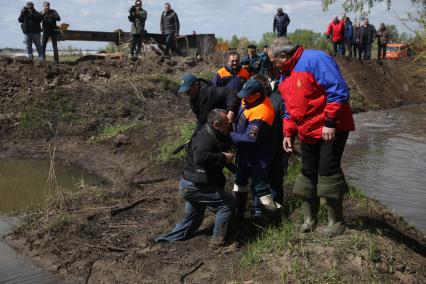 Тюменская область, Ишим. Глава МЧС России Владимир Пучков (справа) помогает фотокорреспонденту `Комсомольской правды` Владимиру Веленгурину (слева) выбраться из болота.