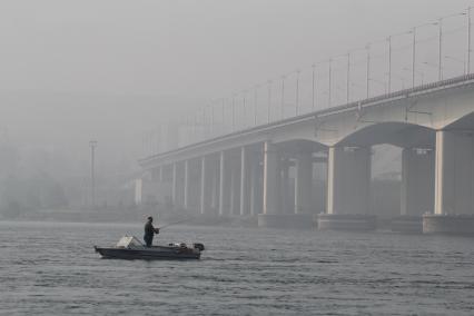 Иркутск.  Рыбак  у Академического моста на реке Ангаре.