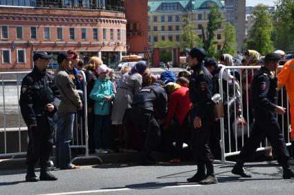 Москва. Оказание помощи женщине, стоявшей в очереди  на Пречистенской набережной к храму Христа Спасителя, где находится ковчег с мощами святителя Николая Чудотворца.