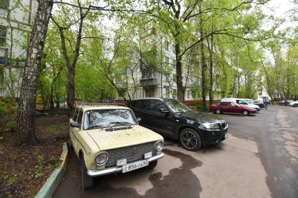 Москва.  Припаркованные автомобили во дворе жилого пятиэтажного дома.