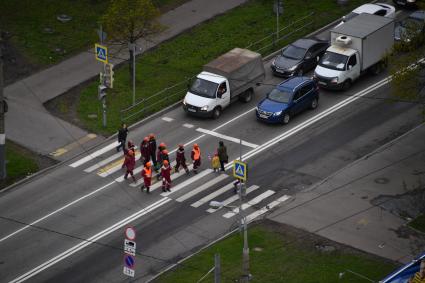 Москва.  Рабочие переходят дорогу по пешеходному переходу в районе Бескудниково.