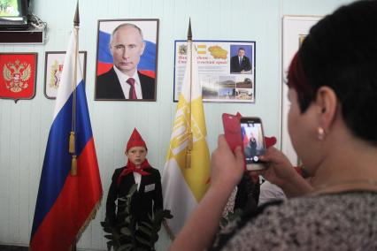 Ставрополь.  Мальчик в пионерском галстуке фотографируется у портрета президента РФ Владимира Путина.