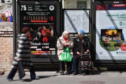 Москва. Бабушки сидят на остановке городского транспорта.