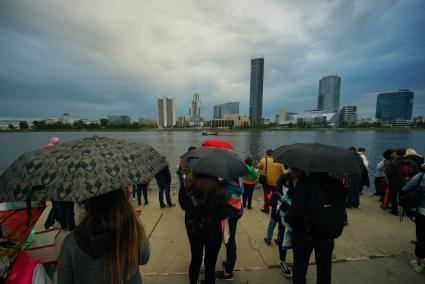 Екатеринбург. Люди под зонтиками у набережной городского пруда. Фестиваль водных фонариков