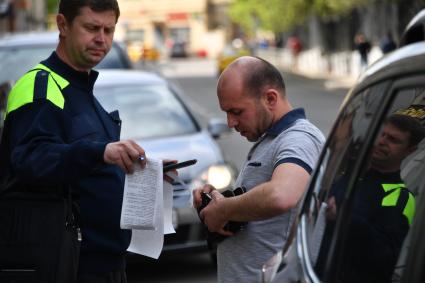 Москва.    Сотрудник `Московского паркинга` общается с автовладельцем/