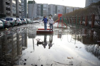 Екатеринбург. Дети играют на затопленной детской площадке