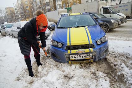 Екатеринбург. Девушка откапывает застрявшую в снегу машину