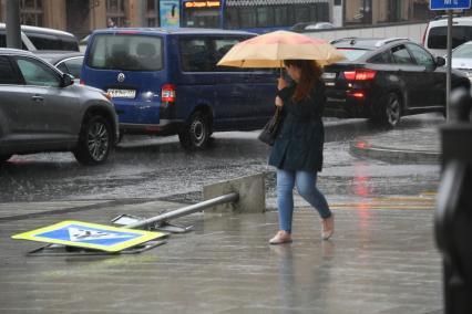 Москва.   Поваленный ураганом дорожный знак на одной из улиц города.