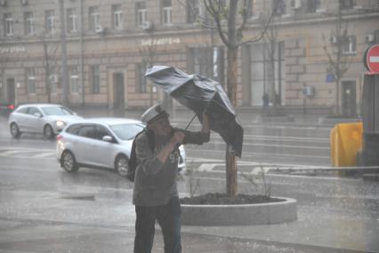 Москва. Мужчина во время урагана на одной из улиц города.