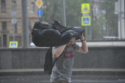 Москва. Молодой человек во время урагана на одной из улиц города.