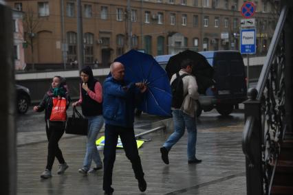 Москва.  Прохожие во время урагана на одной из улиц города.