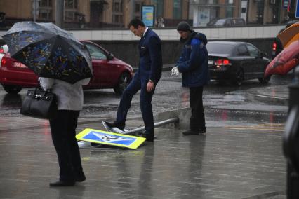 Москва.   Поваленный ураганом дорожный знак на одной из улиц города.