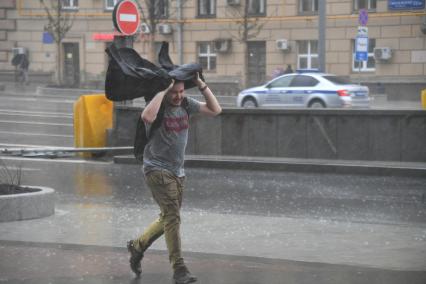 Москва. Молодой человек во время урагана на одной из улиц города.